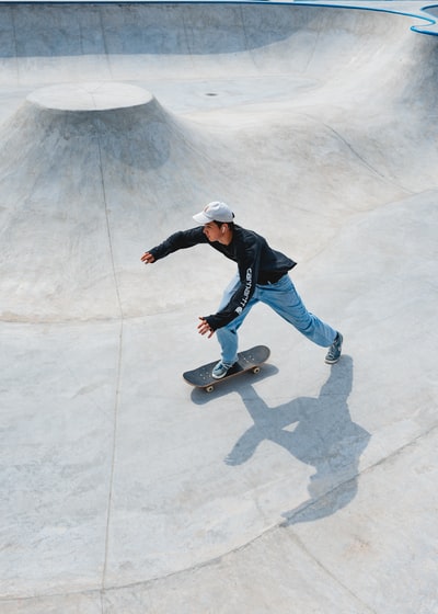 man in blue jacket and blue denim jeans riding skateboard